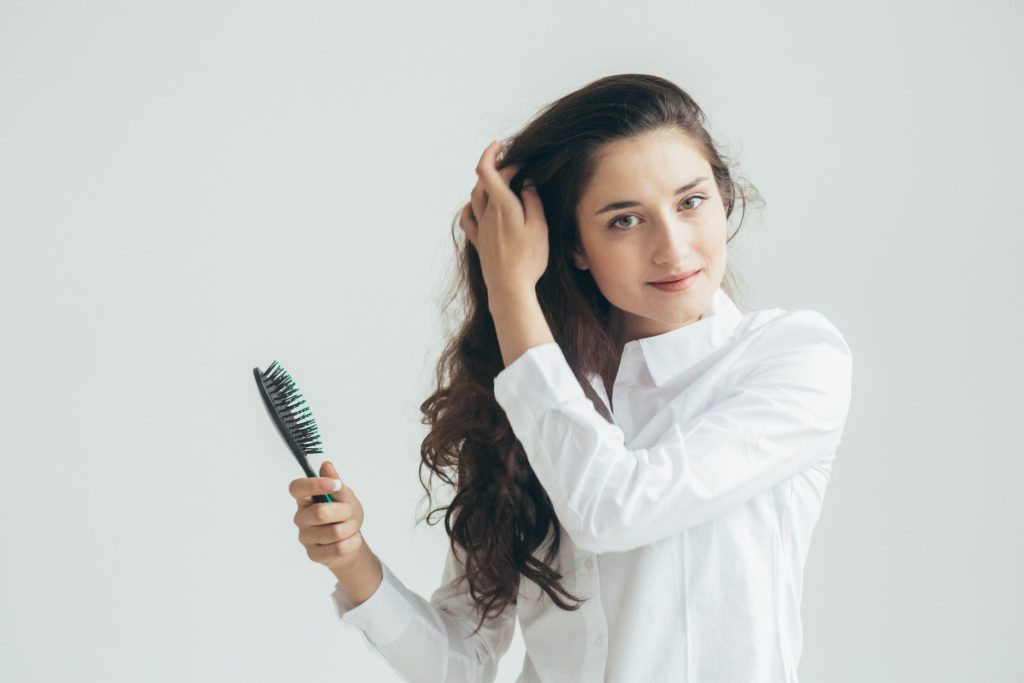 Woman comb hair with hair brush healthy hair beauty concept, natural female portrait at home